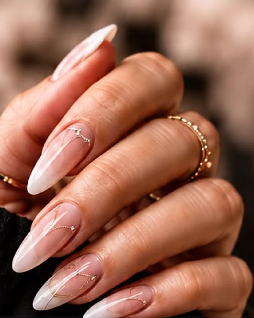 Mains d'une prothésiste ongulaire mettant en valeur un nail art raffiné