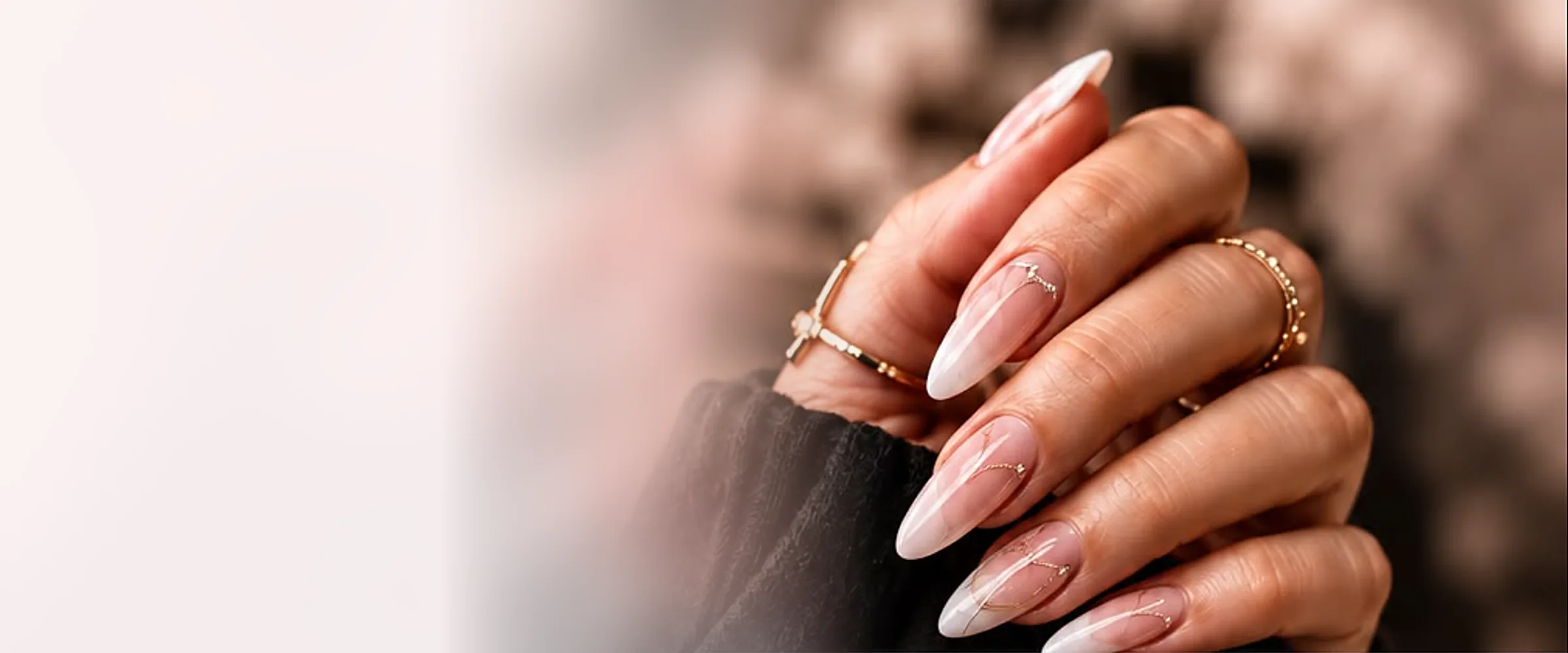 Mains d'une prothésiste ongulaire mettant en valeur un nail art raffiné